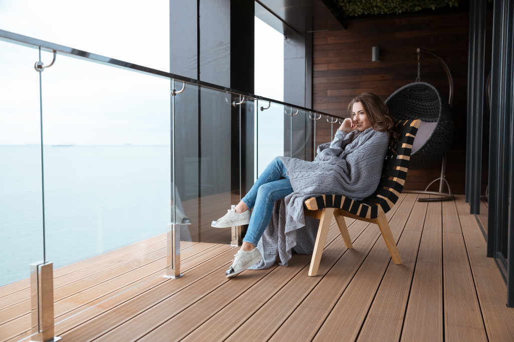 A woman relaxing on a glass balcony