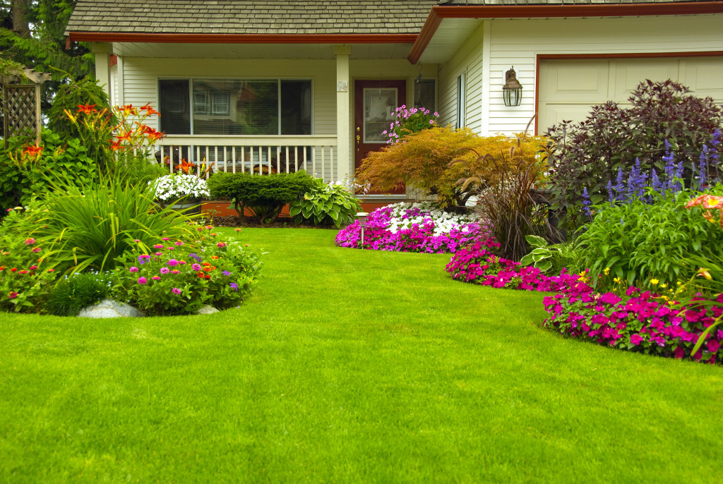 A manicured lawn and garden with colorful flowerbeds