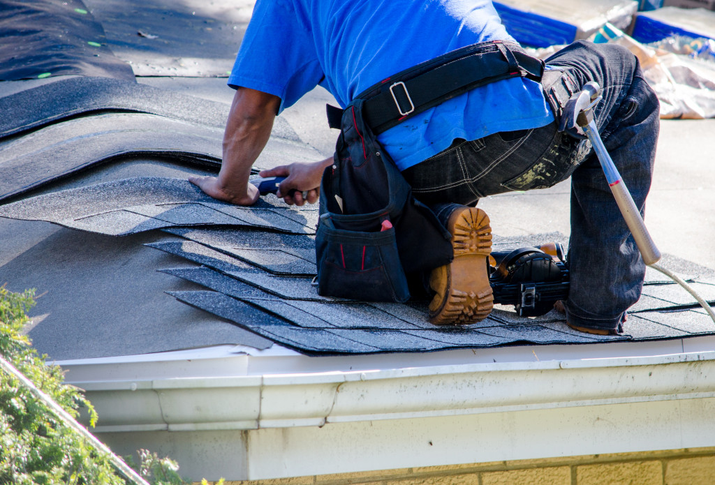Roofing professional fixing a roof of a home.