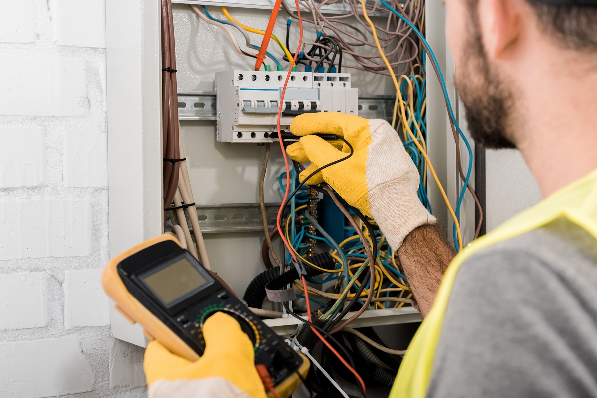 An electrician checking an electrical panel